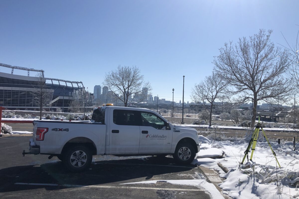 White CobbFendley pick up truck with surveying equipment in the snow on a clear day in the Winter time.