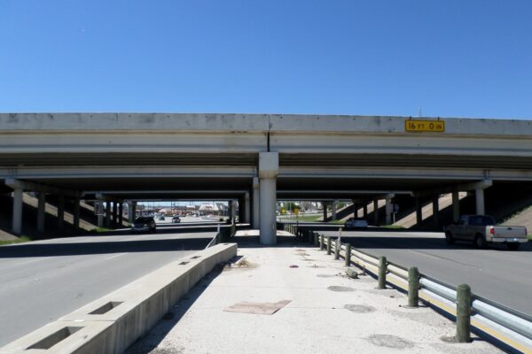 View of two land divided roadway going under a bridge/roadway overpass in Forth Worth, Texas