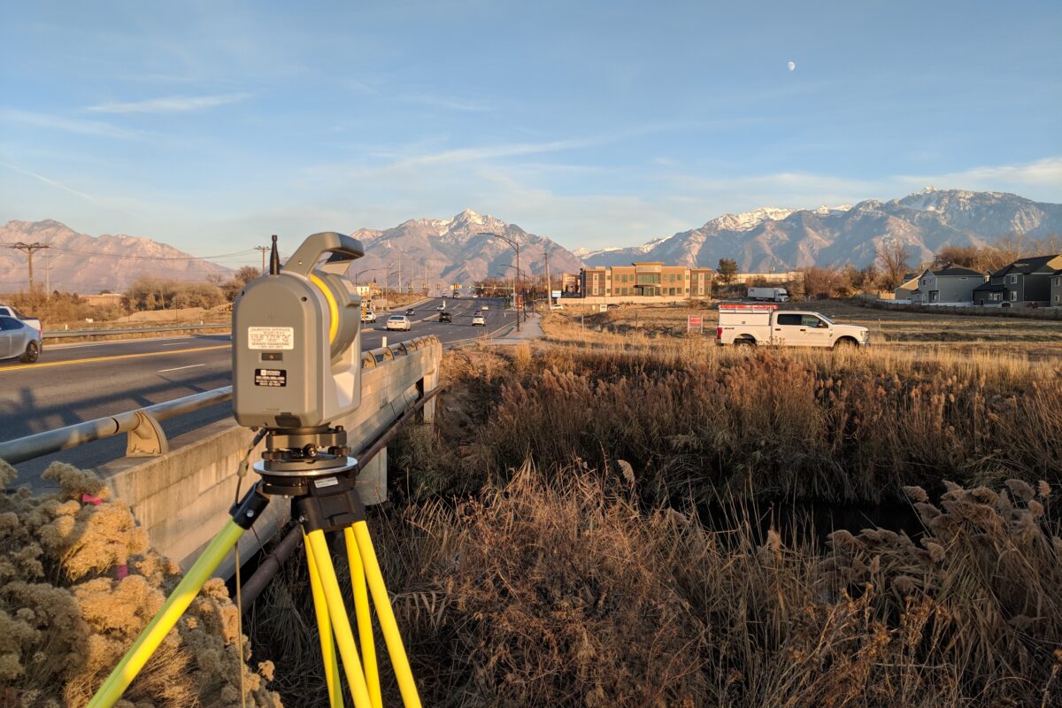 surveying equipment in field in front of mountains